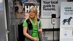Anjing pelacak virus corona bernama Miina (kiri) dan Kössi bersama pelatih, Susanna Paavilainen di bandara Helsinki di Vantaa, Finlandia, Selasa (22/9/2020). Mereka dilatih untuk mendeteksi bau khas infeksi Covid-19 dari penumpang yang datang di bandara. (Antti Aimo-Koivisto/Lehtikuva/AFP)