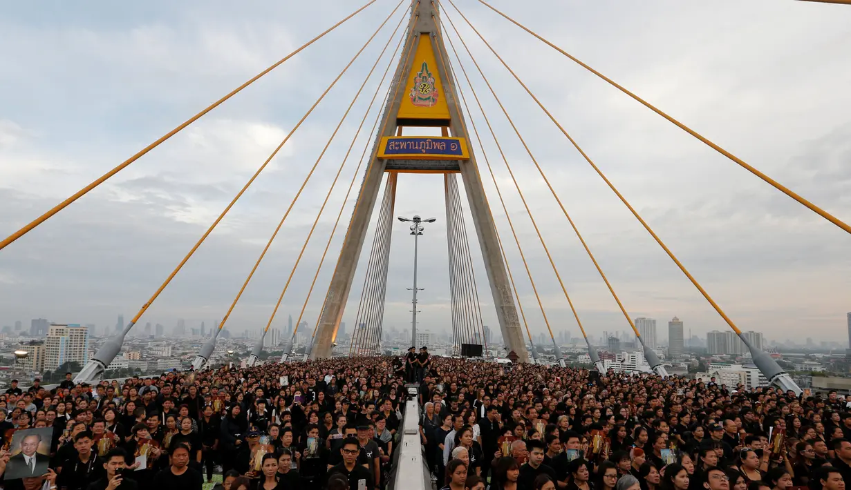 Ribuan warga hadir mengenakan baju hitam-hitam saat acara HUT terakhir almarhum Raja Thailand, Bhumibol Adulyadej di atas Jembatan Bhumibol, Bangkok, Thailand, Senin (5/12). Raja Bhumibol meninggal di usia 88 tahun. (REUTERS/Jorge Silva)