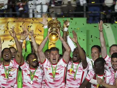 Pemain Leipzig merayakan kemenangan dengan mengangkat trofi DFB Pokal atau Piala Liga Jerman usai mengalahkan SC Freiburg pada partai final yang berlangsung di Stadion Olimpiade di Berlin, Jerman, Sabtu, 21 Mei 2022 waktu setempat. Die Bullen berhasil menang lewat babak adu penalti dengan skor 4-2 usai laga berjalan imbang 1-1. (AP/Michael Sohn)