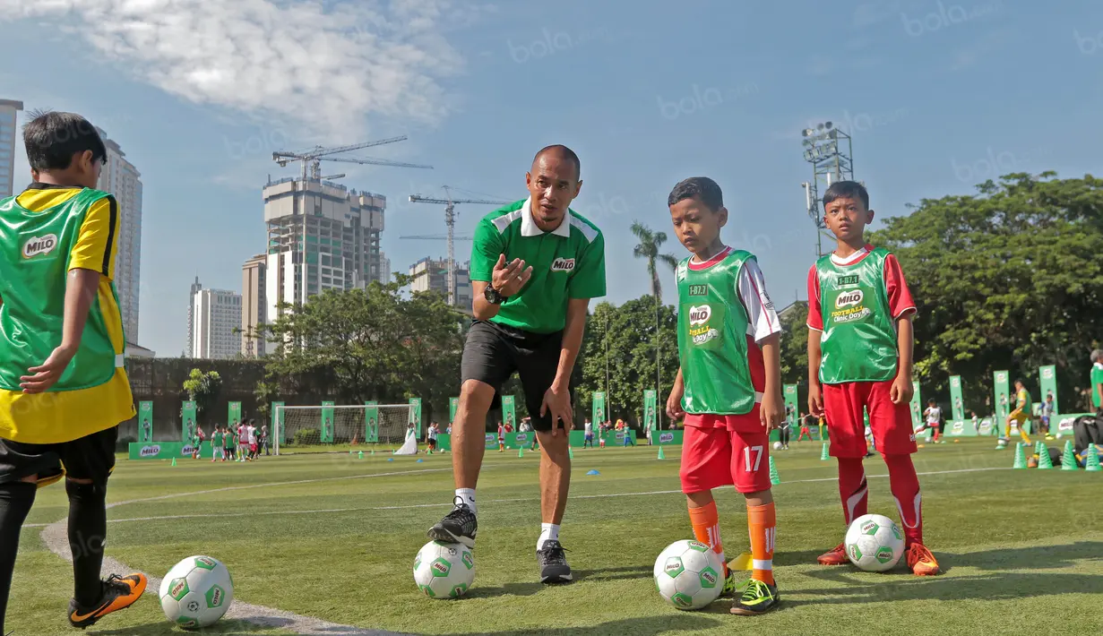 Kurniawan Dwi Yulianto saat membagi tips menggiring bola untuk siswa Sekolah Dasar pada ajang Milo Football Clinic Day, Minggu (30/10/2016) di Simprug. (Bola.com/Nicklas Hanoatubun)