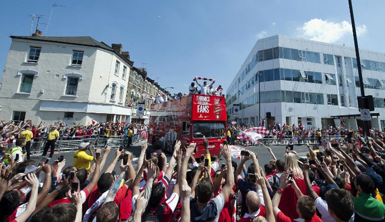 Usai meraih gelar juara Piala FA 2014, para pemain Arsenal langsung mengadakan parade kemenangan di London, Inggris, (18/5/2014). (AFP PHOTO/Oliver Will)