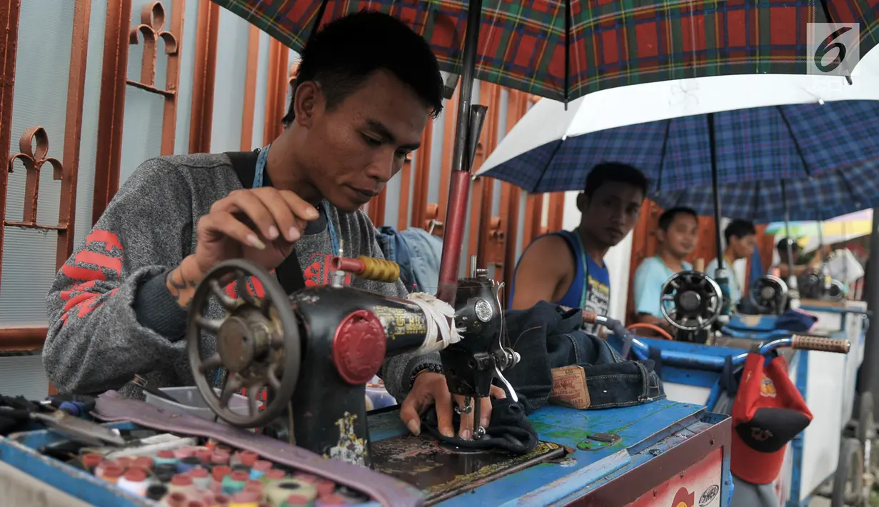 Penjahit keliling saat saat menerima orderan pelanggan, Jakarta, Kamis (22/6). Para penjahit yang biasanya berkeliling masuk kampung ini lebih memilih untuk mangkal di saat jelang lebaran. (Liputan6.com/Yoppy Renato)