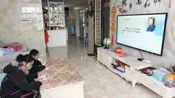Anak kembar, Hu Jintao dan Hu Jinyan, belajar menggunakan TV jaringan di rumah mereka di Provinsi Jiangxi, 10 Februari 2020. Karena sekolah-sekolah di China diwajibkan menunda permulaan semester musim semi, para siswa di Provinsi Jiangxi belajar di rumah dengan berbagai cara. (Xinhua/Liu Jigang)