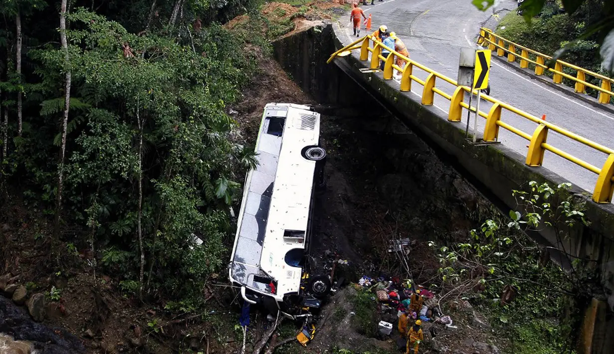 Petugas penyelamat melakukan evakuasi bus yang jatuh di jalan penghubung Medellin dan Bogota dekat San Luis, Provinsi Antiokia, Kolombia, 27 Desember 2021. Tujuh orang, termasuk seorang wanita hamil, tewas dan 20 lainnya luka-luka ketika sebuah bus terjun ke jurang. (Fredy BUILES/AFP)