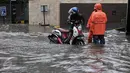 Seorang pengendara motor mendorong kendaraanya yang mogok akibat menerobos banjir di kawasan Kemang, Jakarta Selatan, Rabu (26/4). Hujan deras yang mengguyur wilayah Jakarta menyebabkan banjir di kawasan Jalan Kemang Raya. (Liputan6.com/Yoppy Renato)