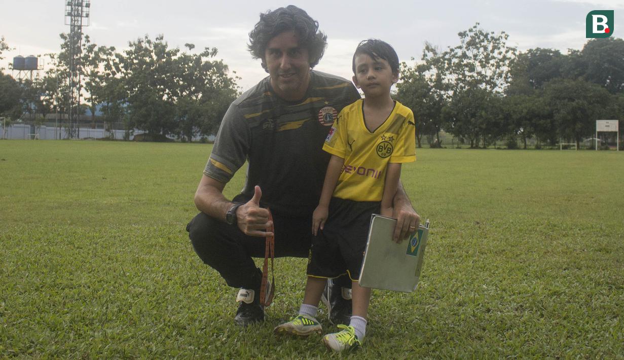 Pelatih Persija Jakarta, Stefano Teco, bersama sang putra, Romario usai memimpin latihan di Lapangan Sutasoma, Jakarta, Minggu (25/2/2018). Ketika ayahnya bekerja sang anak asyik bermain sepak bola. (Bola.com/Aspirilla Dwi Adha)