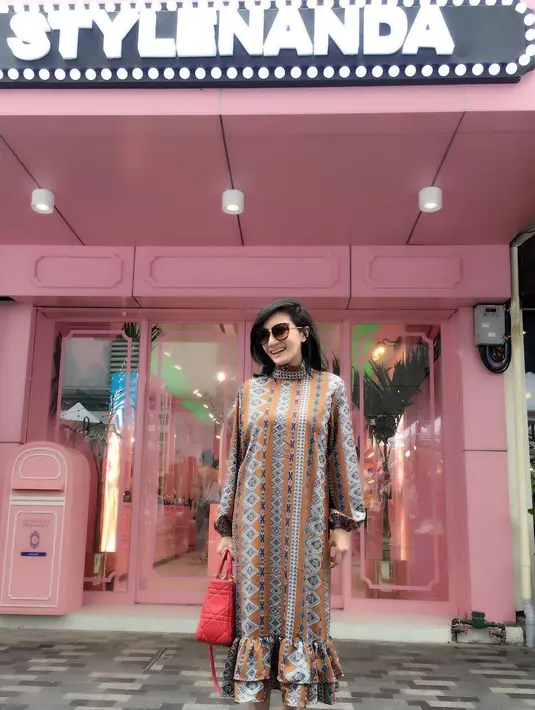 Nah kalau yang satu ini  Kiki mengenakan long dress bermotif etnik dengan bagian bawahnya yang bermodel rempel. Tas jinjing berwarna merah menjadi pemanis penampilannya kali ini. (Instagram/kikiamaliaworld)