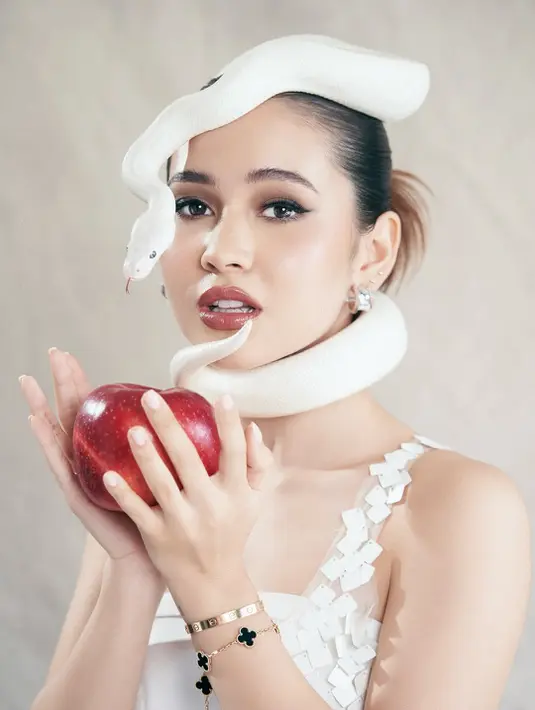 Sandrina tampil cantik berpulas makeup bold dengan smokey eye dan lipstik cokelat gloss. Rambut mediumnya ditata sleek up do [@sandrinna_11]