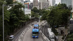 Sebuah bus atap terbuka membawa anggota delegasi Olimpiade Hong Kong selama parade, setelah Olimpiade Tokyo 2020, di Hong Kong, Kamis (19/8/2021). Hong Kong yang memiliki 46 atlet perwakilan pada Olimpiade Tokyo 2020 berhasil mengumpulkan satu emas, dua perak dan tiga perunggu. (ISAAC LAWRENCE/AFP)