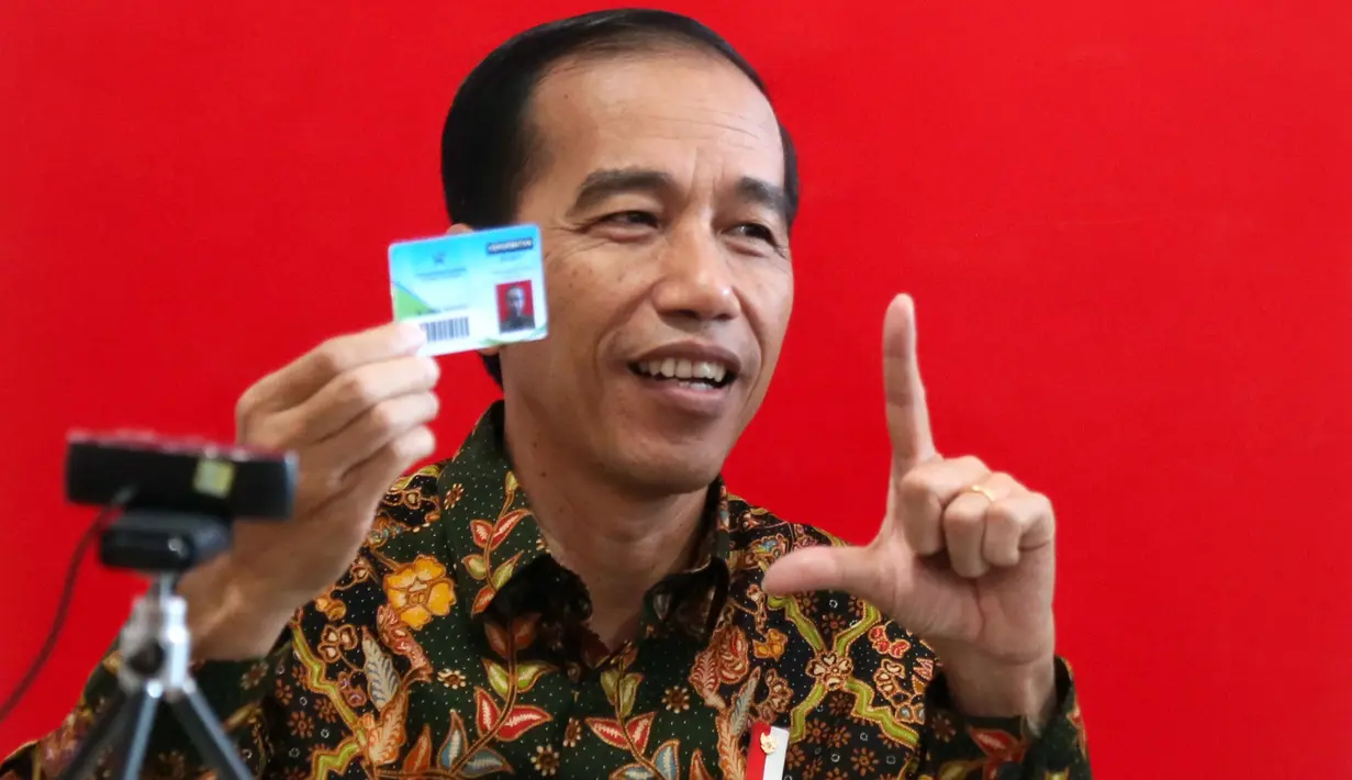 Presiden Joko Widodo atau Jokowi menunjukkan kartu anggota perpustakaan usai meresmikan gedung baru Perpustakaan Nasional di Jakarta, Kamis (14/9). Jokowi berharap perpustakaan ini bisa meningkatkan minat baca masyarakat. (POOL/Kompas/Wisnu Widiantoro)