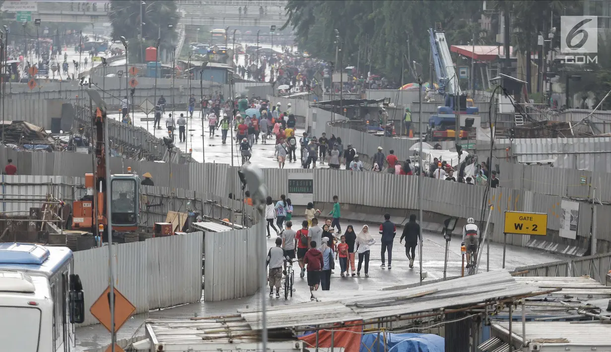 Warga melakukan olahraga dalam kegiatan rutin hari bebas kendaraan bermotor atau car free day (CFD) dikawasan Bunderan HI, Jakarta, Minggu (4/2). Warga tetap melanjutkan aktivitasnya walaupun gerimis mengguyur. (Liputan6.com/Faizal Fanani)