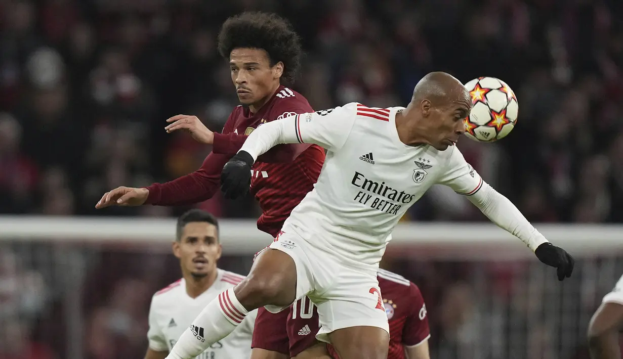Penyerang Bayern Munchen, Leroy Sane berebut bola dengan gelandang Benfica Lisbon, Joao Mario pada pertandingan keempat Grup E yang dihelat di Allianz Arena, Rabu (3/11/2021) dini hari WIB. Munchen sukses menghajar Benfica dengan skor 5-2. (AP Photo/Matthias Schrader)