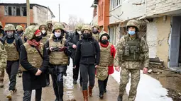 Menteri Luar Negeri Jerman Annalena Baerbock (keempat kanan) berjalan saat berkunjung di Shyrokyne, Wilayah Donetsk, Ukraina (8/2/2022). Menurut kantor berita Jerman DPA, tidak ada kekerasan yang terjadi selama kunjungan Annalena Baerbock. (AFP/Pool/Bernd von Jutrczenka)
