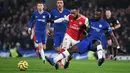 Striker Arsenal, Alexandre Lacazette, berebut bola dengan bek Chelsea, Antonio Rudiger, pada laga Premier League pekan ke-24 di Stamford Bridge, London, Rabu (22/1). Arsenal tahan imbang Chelsea 2-2. (AFP/Daniel Leal-Olivas)