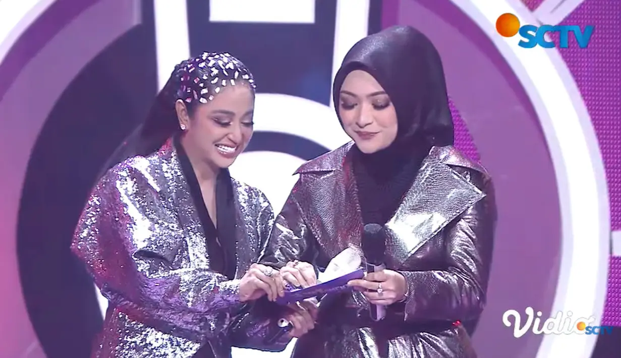 Dewi Perssik dan Nathalie Holscher tersenyum saat hendak membuka nama pemenang kategori Gorgeous Dad.