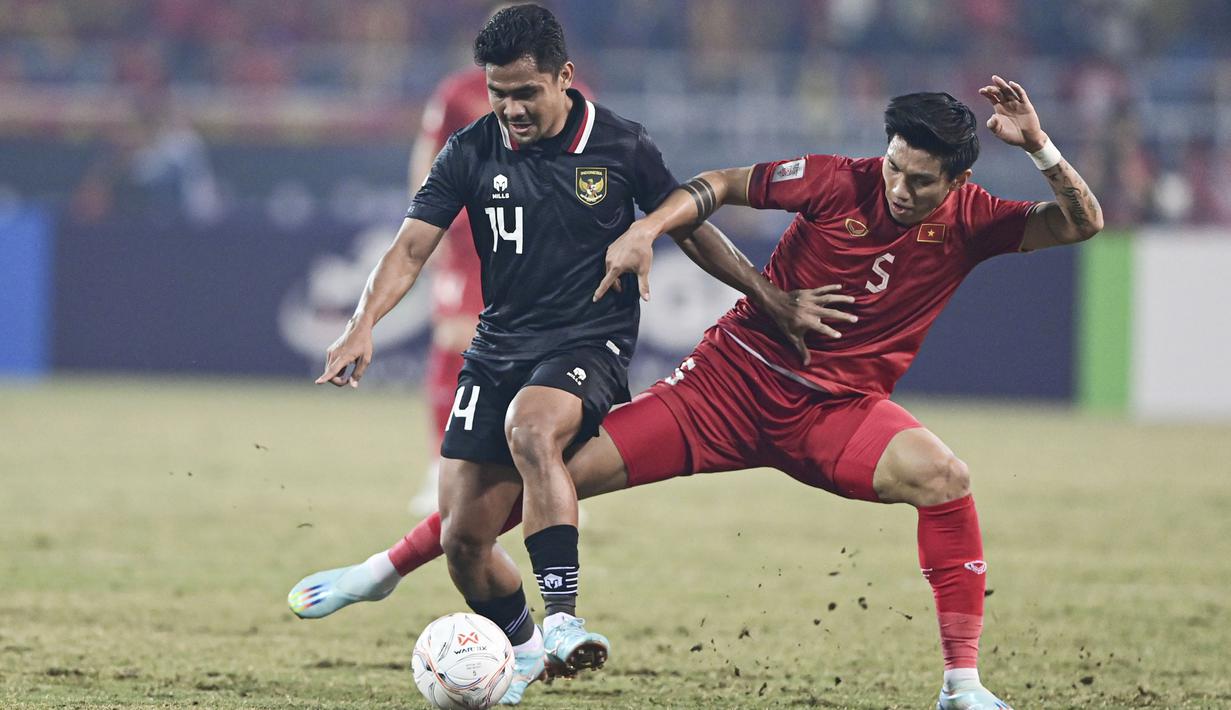 Pemain Vietnam, Doan Van Hau, berebut bola dengan pemain Timnas Indonesia, Asnawi Mangkualam, pada laga leg kedua semifinal Piala AFF 2022 di Stadion Nasional My Dinh,  Senin (9/1/2023). (AP Photo/Nguyen Manh Quan)