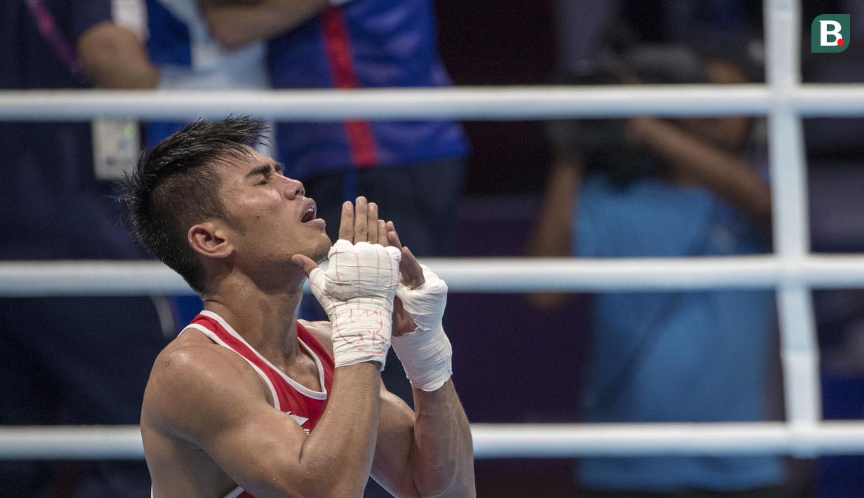 Ekpresi kecewa petinju Indonesia Sunan Agung Amoragam usai dikalahkan oleh Mirazizbek Mirzakhalilov asal Uzbekistan di babak semifinal kelas bantam (56 kg) Asian Games 2018 di JIExpo Kemayoran Jakarta pada Jumat (31/8/2018). (Bola.com/Peksi Cahyo)