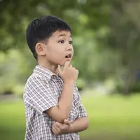 Seorang anak laki-laki tampak sedang berpikir di sebuah taman (Foto Dok: Freepik/jcomp)