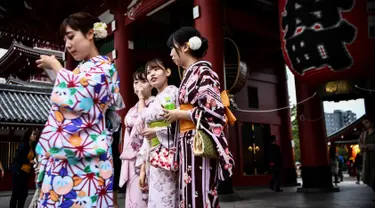 Gambar pada 21 Oktober 2019 menunjukkan sejumlah perempuan mengenakan pakaian tradisional Jepang, kimono, saat mengunjungi kuil Senso-ji di Tokyo. Sensoji Temple merupakan salah satu kuil tertua di Jepang yang terletak di Asakusa. (Anne-Christine POUJOULAT / AFP)