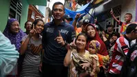 Calon Gubernur DKI Jakarta Agus Harimurti Yudhoyono (AHY) berfoto bersama warga saat blusukan di kawasan Kampung Pulo, Jakarta, Selasa (27/12). AHY datang ke tempat tersebut untuk mendengarkan keluhan warga. Liputan6.com/Gempur M Surya)