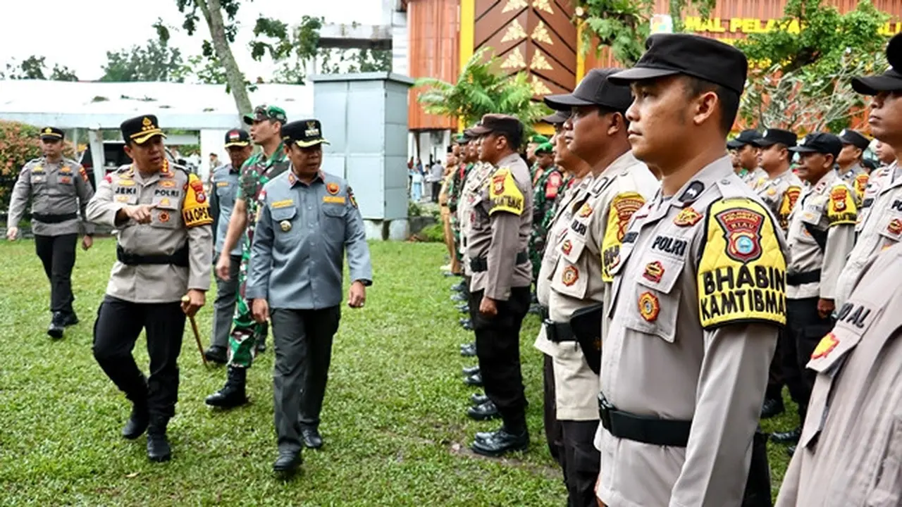 Kapolresta Pekanbaru Jeki Rahmat Mustika mengecek barisan Bhabinkatimbas yang diturunkan memantau TPS.