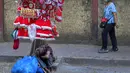 Pedagang pinggir jalan yang menjual suvenir Natal tidur siang sambil menunggu pembeli di Mumbai, India, Selasa (20/12/2022). Jelang puncak perayaan Natal, warga Mumbai mulai ramai berburu ornamen dan aksesoris Natal untuk menyambut dan memeriahkan perayaan untuk umat kristiani tersebut. (AP Photo/Rafiq Maqbool)