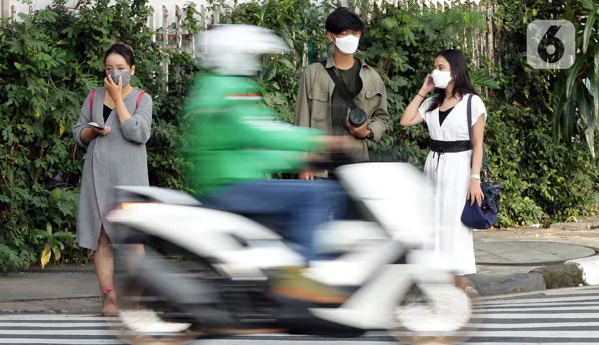 Pejalan kaki menanti waktu menyebrang di Jalan Jenderal Sudirman, Jakarta, Minggu (21/11/2021). Untuk mencegah lonjakan kasus Covid-19, pemerintah akan menerapkan kebijakan PPKM Level 3 untuk seluruh wilayah Indonesia selama masa libur Natal 2021 dan Tahun Baru 2022.(Liputan6.com/Helmi Fithriansyah)