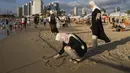 Warga Palestina menikmati hari di pantai saat perayaan Idul Adha, di Tel Aviv, Israel, Kamis, 29 Juni 2023. (AP Photo/Oded Balilty)