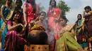 Para wanita India mempersiapkan pongal saat mengikuti kegiatan dalam perayaan festival panen Tamil sebuah perguruan tinggi di Chennai, India (11/1). (AFP Photo/Arun Sankar)