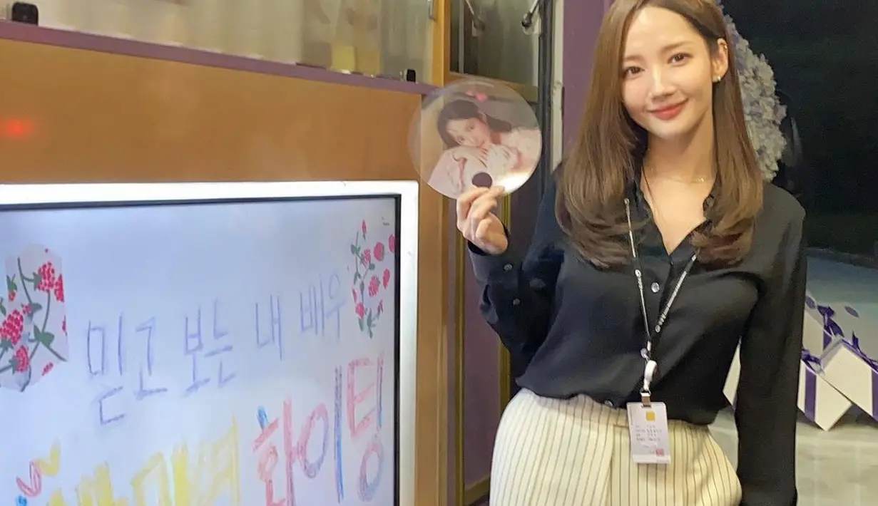 Cantiknya Park Min Young dengan atasan blouse satin lengan panjang berwarna hitam. Ia padukan OOTD kantorannya ini dengan celana panjang bermotif garis berwarna cokelat muda. [Foto: Instagram/rachel_mypark]