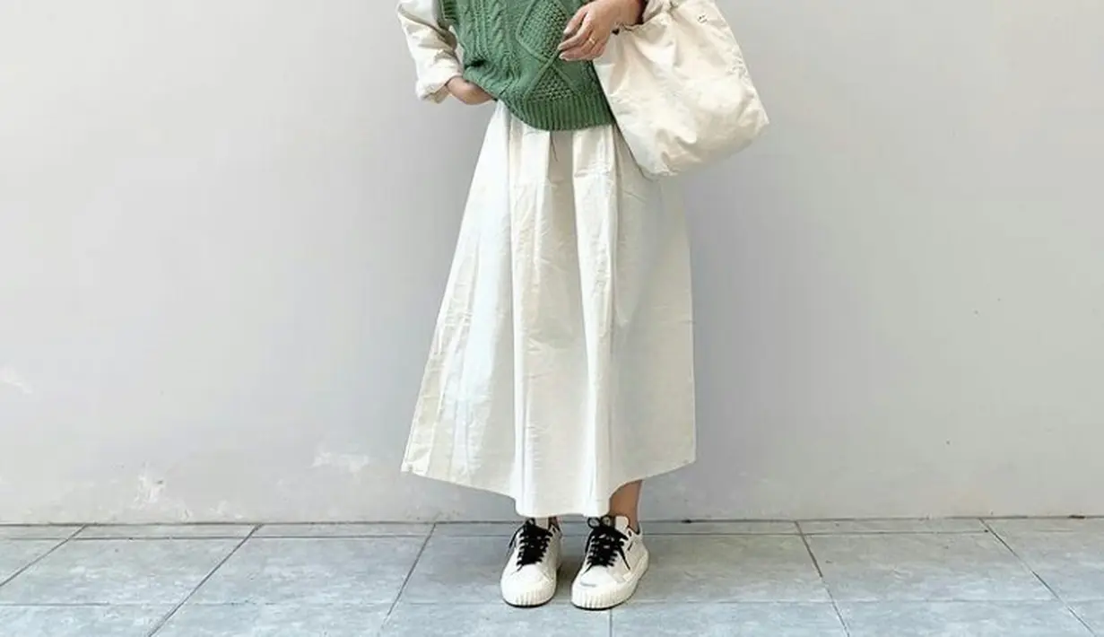 Padukan kemeja polos dan rok warna senada dengan knit vest. Lengkapi penampilanmu dengan sneakers. Cocok buat outfit ke kampus. (Instagram/hanigoods).