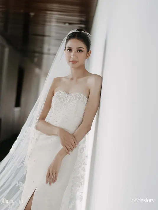 Mikha Tambayong pakai gaun pengantin milik mendiang mama yang dipoles Jeffry Tan. Gaun pengantin klasik model strapless itu mendapat beberapa perubahan seperti detail payet dan taburan beads. [@thebridestory]
