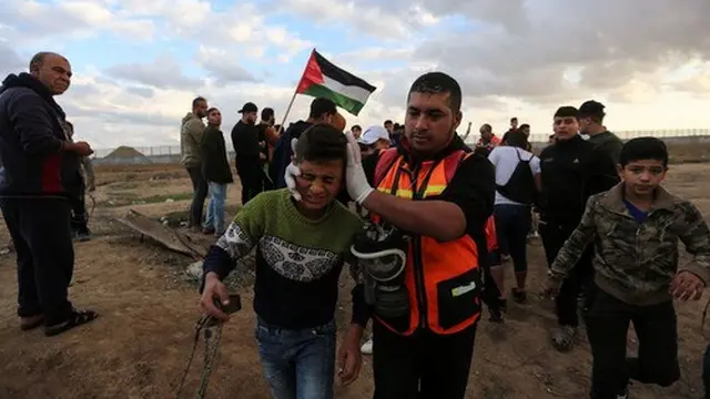 Petugas medis Palestina membantu seorang anak laki-laki yang terluka dalam bentrokan dengan tentara Israel di dekat wilayah perbatasan dengan Israel, Kota Gaza timur, pada 6 Desember 2019. (Xinhua/Mohammed Dahman)