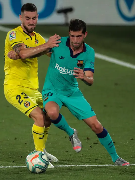 Bek Barcelona, Sergi Roberto berebut bola dengan pemain Villareal, Moi Gomez dalam pekan ke-34 La Liga Spanyol di stadion La Ceramica, Minggu (5/7/2020). Barcelona sukses menumbangkan tim tuan rumah Villarreal dengan skor telak 4-1. (AP Photo/Jose Miguel Fernandez)