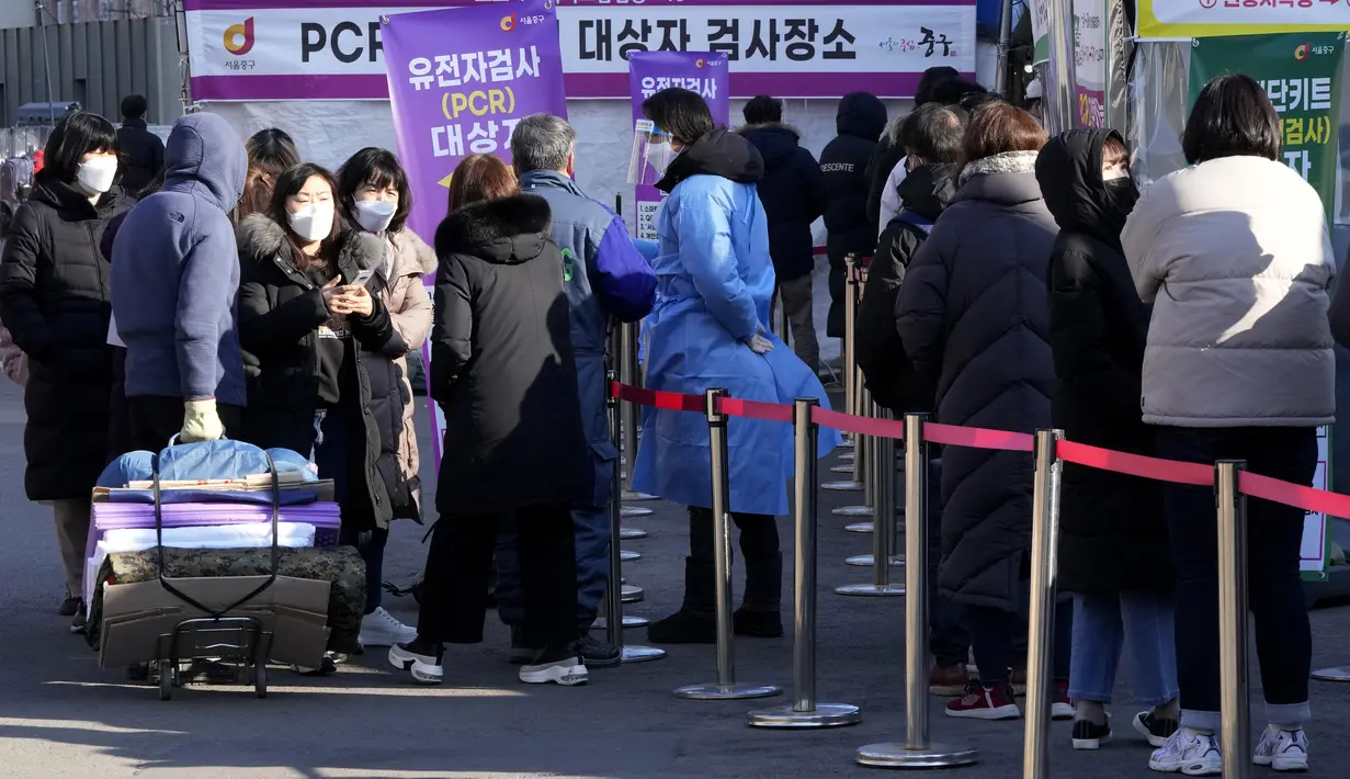 Seorang pekerja medis (tengah) memandu orang-orang saat menunggu tes virus corona di tempat pengujian darurat di Seoul, Rabu (23/2/2022). Kasus harian COVID-19 baru Korea Selatan mencapai rekor tertinggi, melonjak menjadi 171.452 dari 99.569 kasus sehari sebelumnya. (AP Photo/Ahn Young-joon)