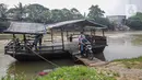 Warga turun dari perahu eretan di Sungai Cisadane, Neglasari, Kota Tangerang, Kamis (7/10/2021). Keberadaan jasa penyeberangan perahu eretan dengan tarif Rp 2.000 tersebut guna mempersingkat jarak tempuh dan waktu. (Liputan6.com/Angga Yuniar)