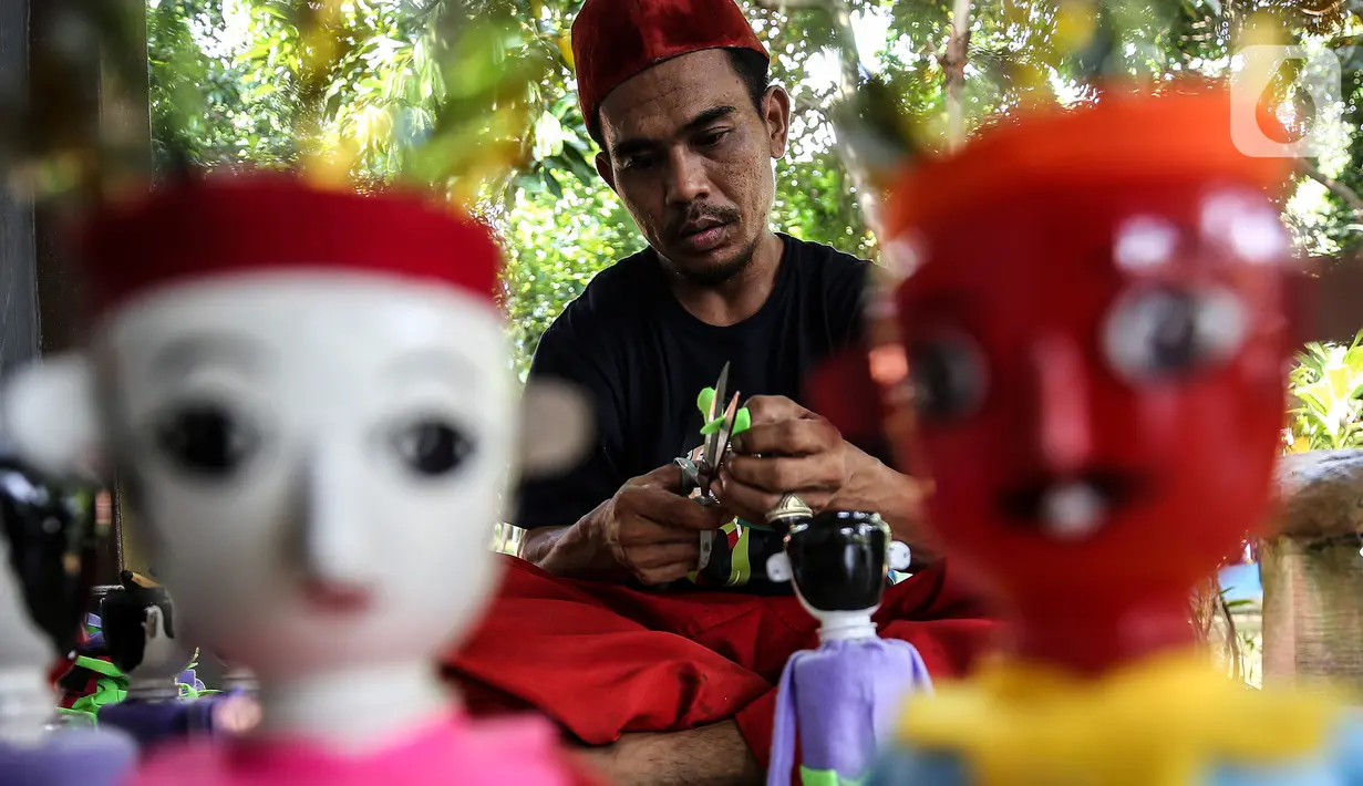 Chairuddin (40) bersama rekannya menyelesaikan pembuatan ondel-ondel dari botol bekas di Sanggar Rumah Kreasi, Jakarta, Minggu (13/6/2021). Botol bekas dimanfaatkan menjadi ondel-ondel untuk dijual dengan harga sepasang Rp35 ribu dan bisa membuat ratusan setiap harinya. (Liputan6.com/Johan Tallo)