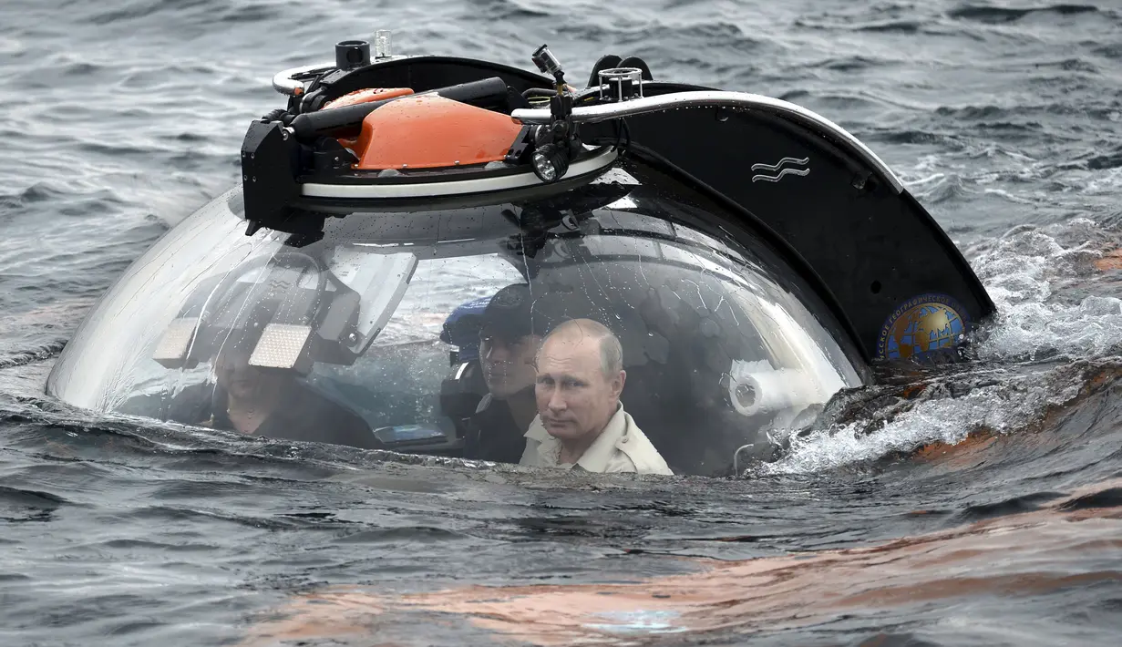 Presiden Rusia Vladimir Putin (kanan) didampingi petugas ketika menjajal kapal selam mini memasuki perairan Laut Hitam saat ekspedisi di Sevastopol, Crimea, Rusia, Selasa (18/8/2015). (REUTERS/Alexei Nikolsky/RIA Novosti/Kremlin)