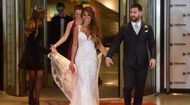 Bintang sepak bola, Lionel Messi berjalan di karpet merah bersama istrinya Antonella Roccuzzo di Rosario, provinsi Santa Fe, Argentina (30/6). Acara ini dihadiri banyak pesepakbola dan selebriti termasuk penyanyi pop Shakira. (AFP Photo/Eitan Abramovich)