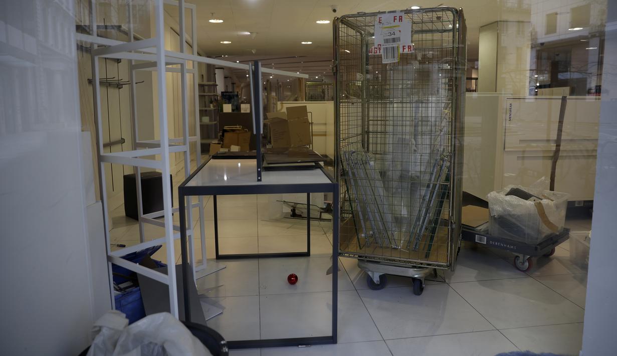 Barang-barang terlihat dari jendela saat proses kemas di dalam department store utama Debenhams yang tutup di Oxford Street di London, Sabtu (6/2/2021). Pengecer mode online, Boohoo telah membeli merek dan situs web Debenhams seharga 55 juta pound atau sekitar Rp 1 triliun. (AP Photo/Matt Dunham)