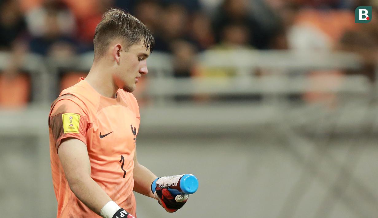 Kiper Timnas Prancis U-17, Paul Argney, melihat contekan di botol minumannya saat adu penalti melawan Senegal U-17 pada babak 16 besar Piala Dunia U-17 2023 di Jakarta International Stadium (JIS), Rabu (22/11/2023). (Bola.com/M Iqbal Ichsan)