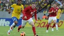 Wayne Rooney menggiring bola melewati pemain Brazil, Paulinho pada laga persahabatan di Stadion Maracana, Brazil, Minggu (2/6/2015). (AFP Photo/Yasuyoshi Chiba)