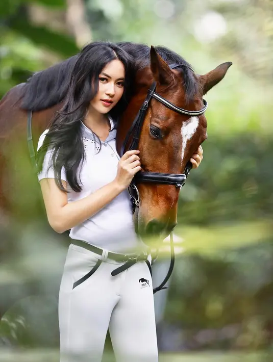 Menggunakan pakaian serba putih, pemenang kontes Puteri Indonesia 2014 ini tampak sangat cantik dengan rambut yang terurai. Pemeran film "Dilarang Menyanyi di Kamar Mandi" ini tampak nyaman memegang kuda di sampingnya. (Liputan6.com/IG/@elviraelph)