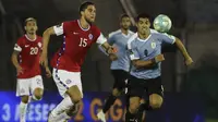 Penyerang Uruguay, Luis Suarez, berebut bola dengan bek Chile, Francisco Sierralta, pada laga kualifikasi Piala Dunia 2020 zona Amerika Selatan di Estadio Centenario, Jumat (9/10/2020) pagi WIB. Uruguay menang 2-1 atas Chile. (AFP/Raul Martinez/various sources)