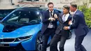 Dua orang tampak membantu CEO BMW, Harald Krueger yang jatuh pingsan saat sedang presentasi selama Frankfurt Motor Show (IAA) di Jerman, Selasa (15/9). Krueger jatuh ketika tengah memberikan ulasan mengenai produk terbaru BMW. (REUTERS/Kai Pfaffenbach)
