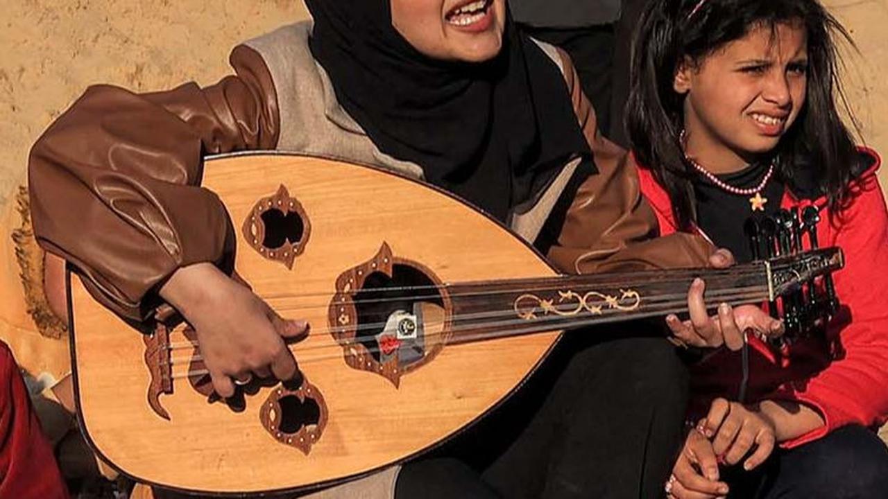 Hassouna mengajak anak-anak Jalur Gaza untuk bernyanyi bersama dengan iringan musik Oud atau kecapi oriental.