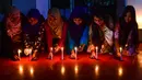 Sejumlah wanita Bangladesh meletakkan lilin saat memperingati Hari Perempuan Internasional di Dhaka (7/3). Hari Perempuan Internasional secara resmi dijadikan sebagai hari libur nasional di Soviet Rusia pada tahun 1917. (AFP Photo/Munir Uzzaman)