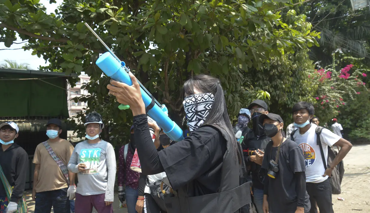 Pengunjuk bersiap dengan senapan angin darurat selama tindakan keras polisi di kotapraja Thaketa di Yangon, Myanmar (27/3/2021).  Kepala junta Myanmar menggunakan kesempatan Hari Angkatan Bersenjata untuk mencoba membenarkan penggulingan pemerintahan terpilih Aung San Suu Kyi. (AP Photo)