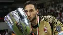 Kiper AC Milan Gianluigi Donnarumma berpose bersama piala setelah memenangkan pertandingan final Piala Super Italia antara AC Milan dan Juventus di Doha pada 23 Desember 2016. (AFP Photo/Karim Jaafar)