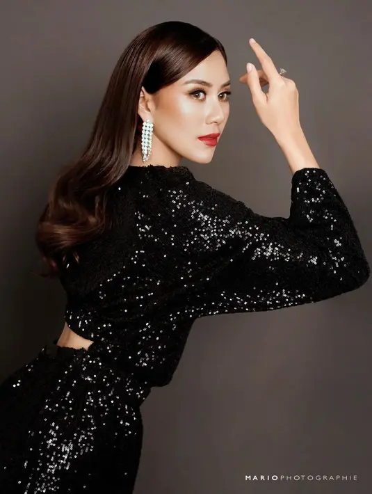 Syahnaz mengenakan gaun sequin hitam panjang dengan anting mutiara dan makeup bold [@mariophotographie]